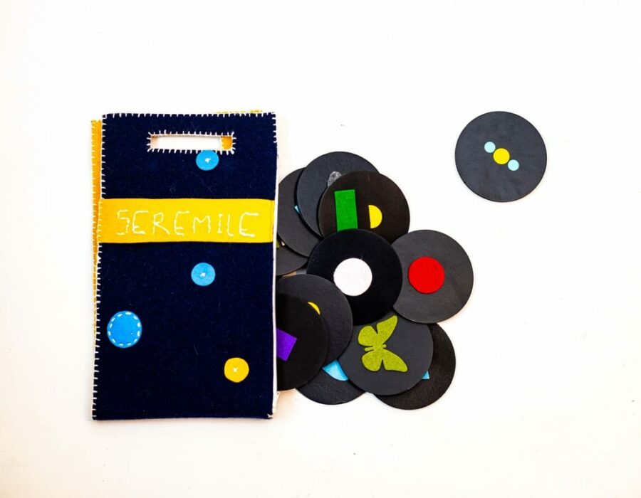 Borsa contenitore blu e gialla ricamata con il nome SerEmiLe con tessere nere rotonde del gioco Memory